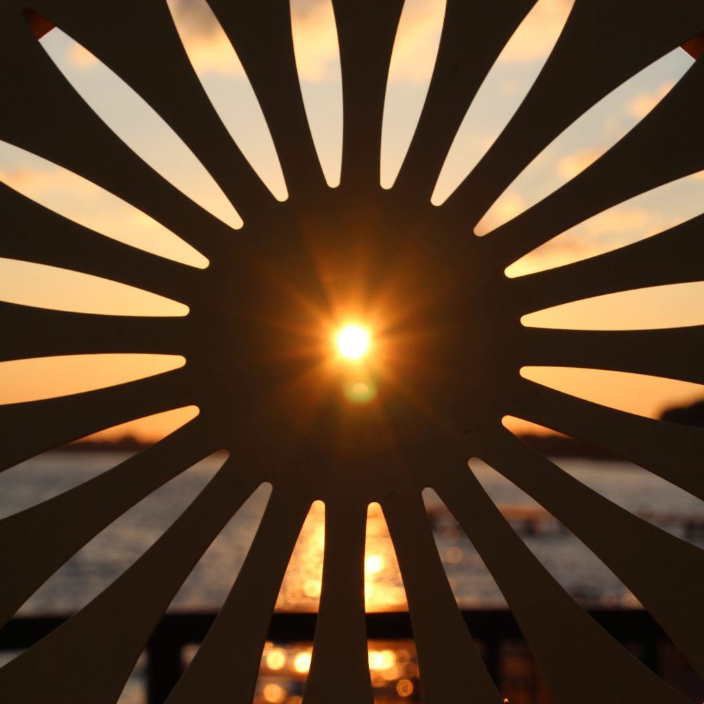 Sun rising through the inside hole of an iconic Memorial Union Chair close up.